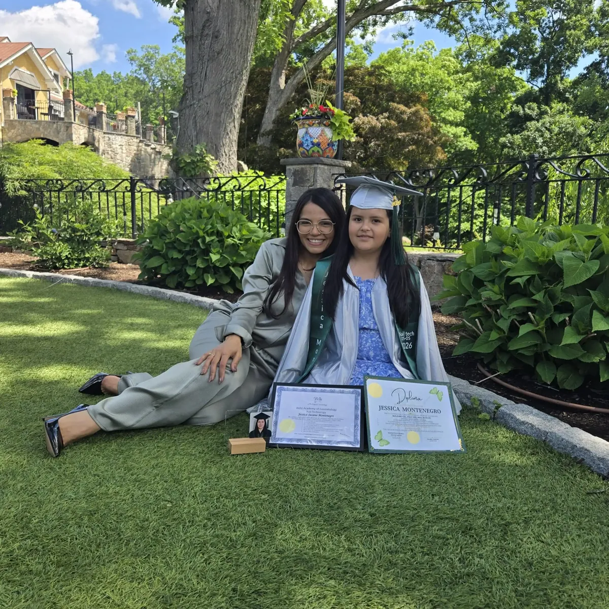 Belle Academy outdoor graduates seated with certificates